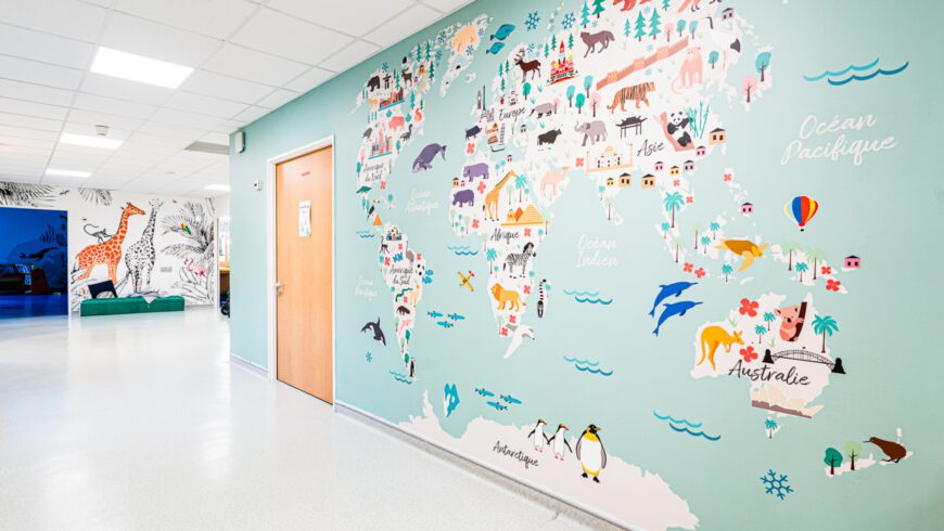 Fresque murale illustrée du Centre Kerpape créée par Pois Chiche Design, carte du monde colorée dans un couloir pédiatrique.