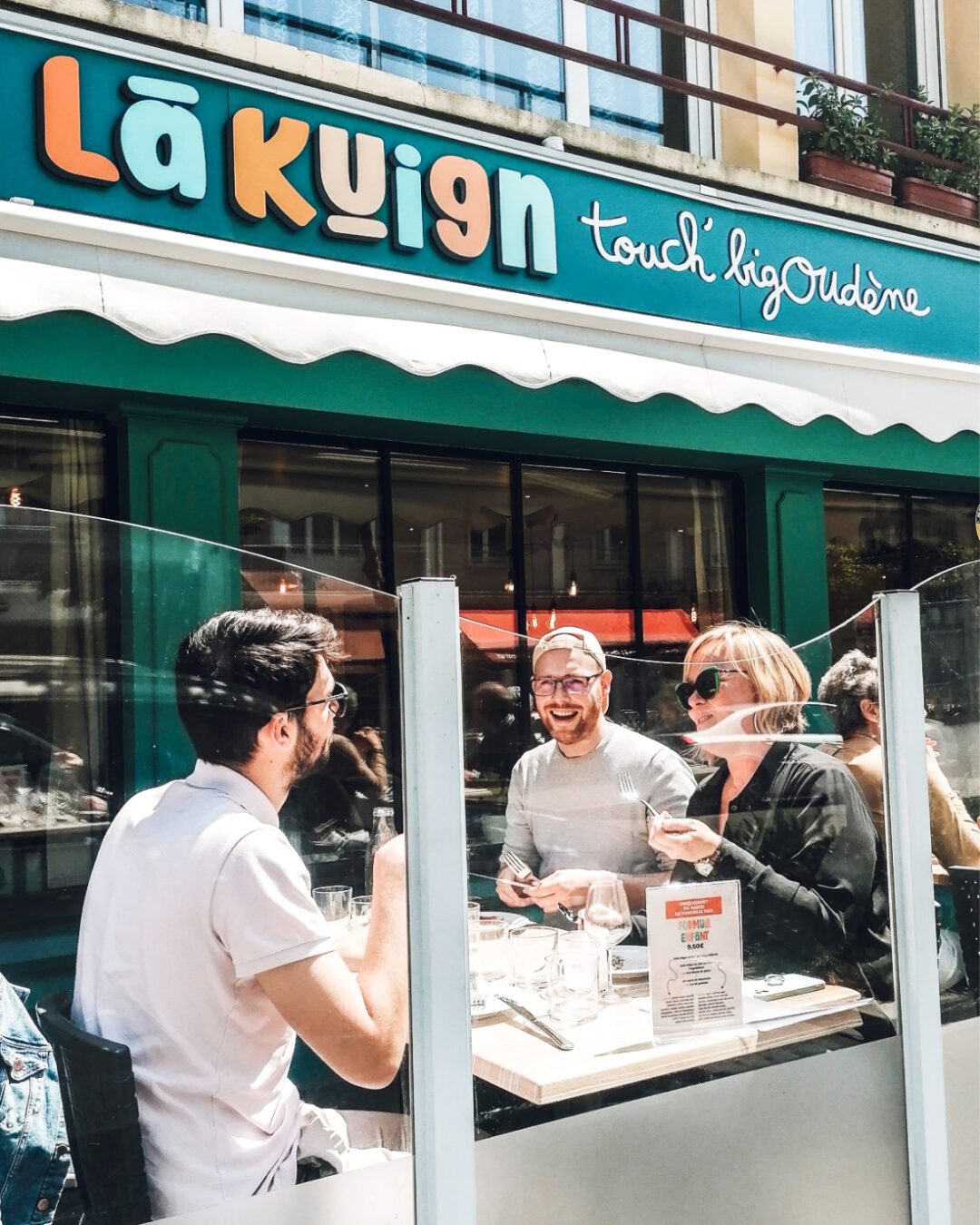 Façade du restaurant Lã Kuign à Lorient avec enseigne colorée “touch’ bigoudène”, identité visuelle créée par Pois Chiche Design.